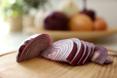 Red cut onion on wooden board, closeup