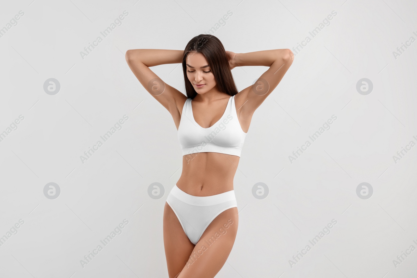 Photo of Young woman in stylish bikini on white background