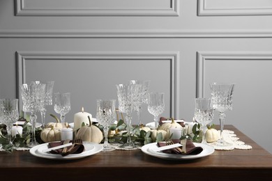 Photo of Beautiful autumn table setting. Plates, cutlery, glasses, blank cards and floral decor