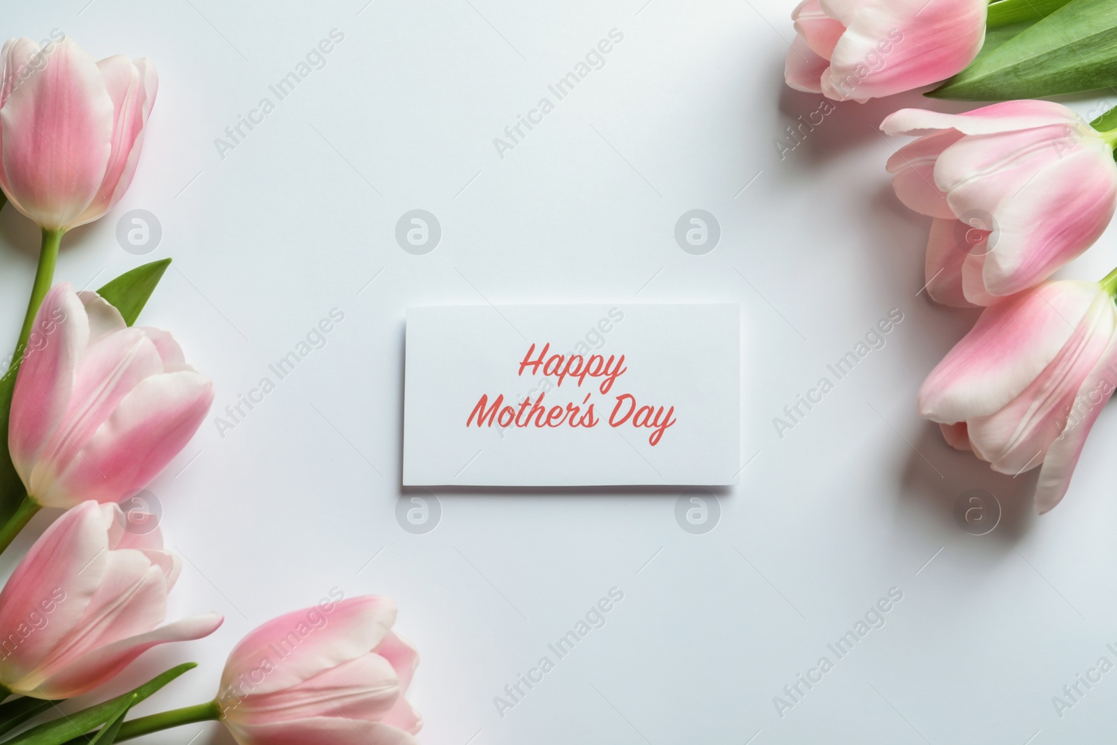 Photo of Beautiful tulips and greeting card with words "Happy Mother's Day" on light background, top view