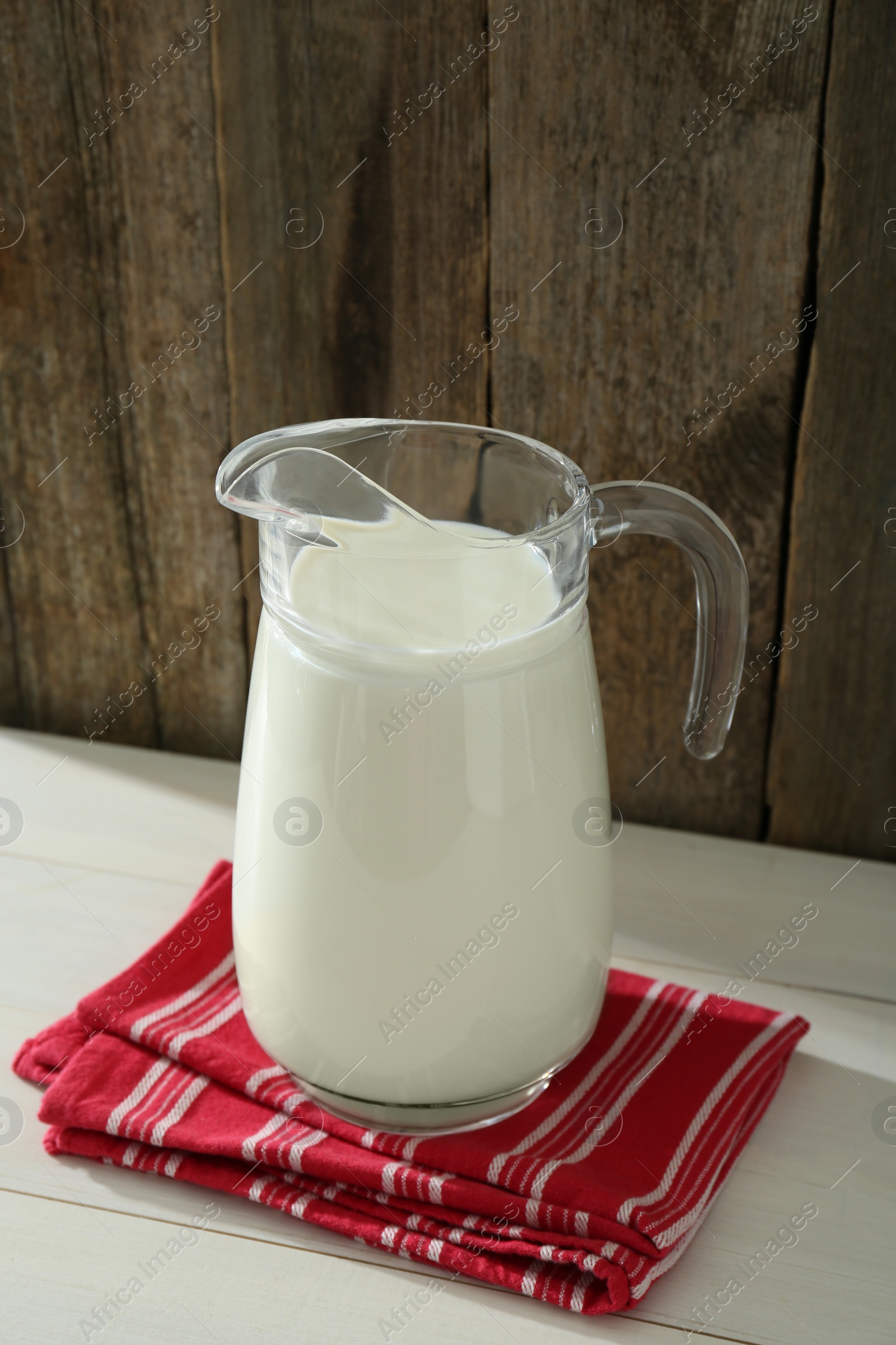 Photo of Jug of fresh milk on white wooden table