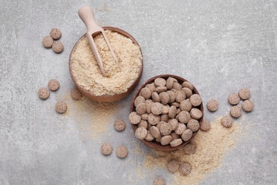 Brewer's yeast flakes and tablets on grey table, flat lay