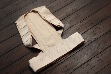 Photo of New beige posture corrector on wooden table
