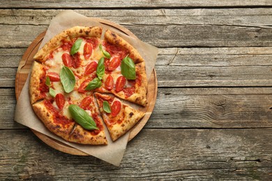 Photo of Delicious Margherita pizza on wooden table, top view. Space for text