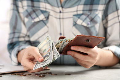 Woman with money at light grey table, closeup