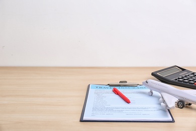 Composition with toy plane and travel insurance form on wooden table. Space for text
