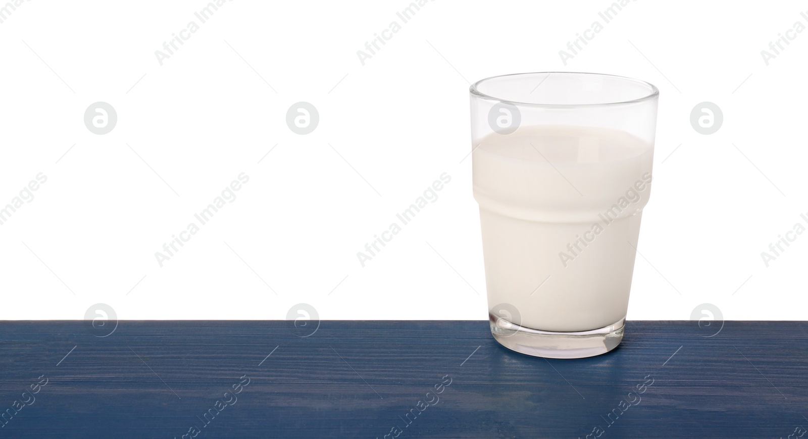 Photo of One glass of tasty milk on blue wooden table against white background