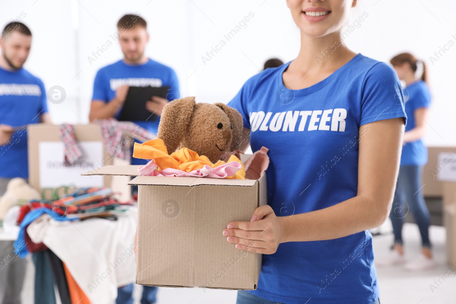 Photo of Female volunteer holding box with donations indoors