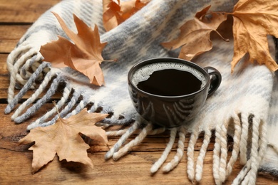 Photo of Composition with hot drink and warm plaid on wooden table