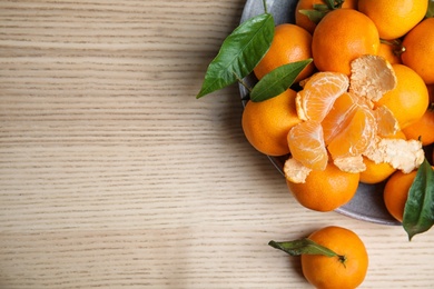 Photo of Fresh ripe tangerines and space for text on wooden background