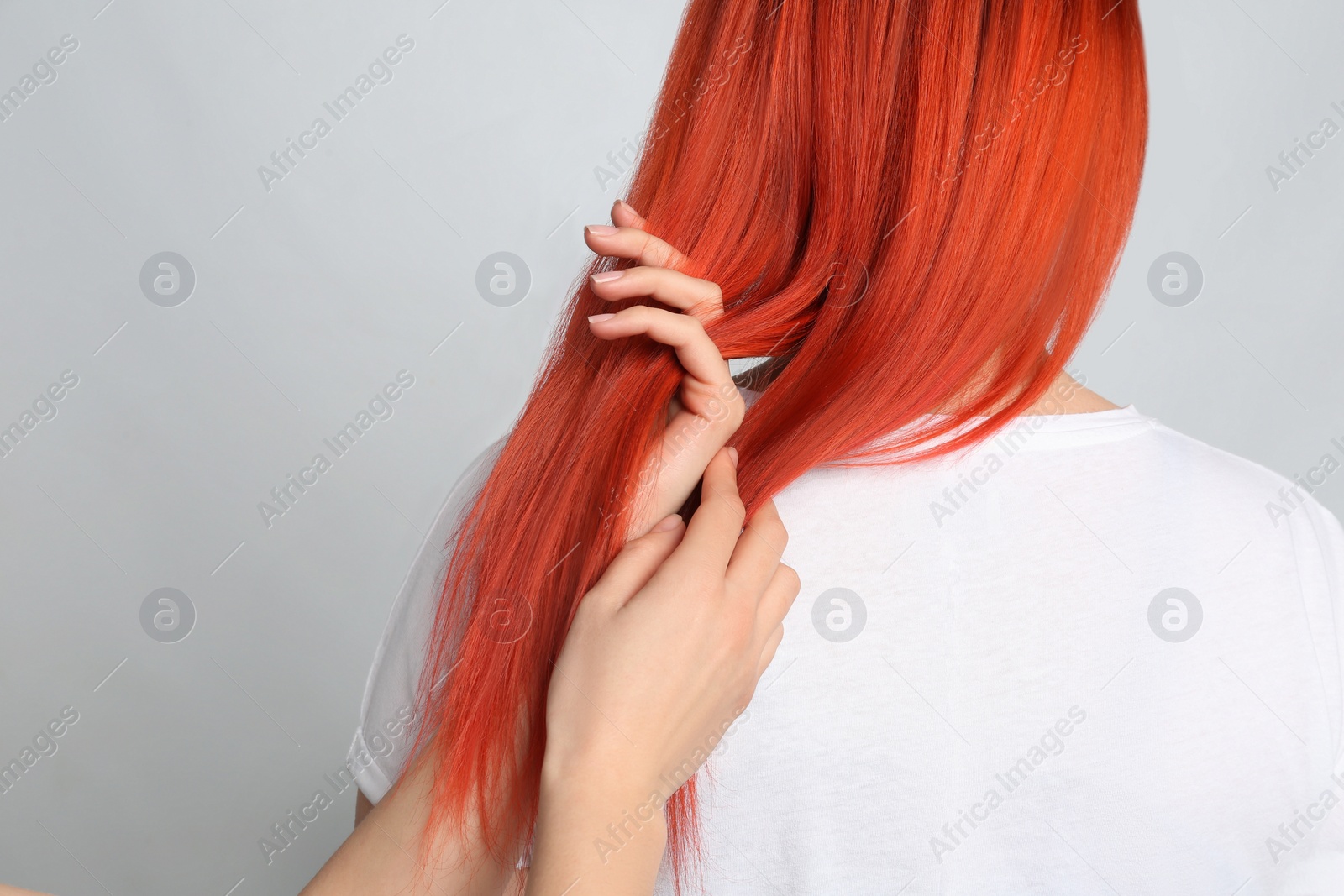 Photo of Woman with bright dyed hair on grey background, back view