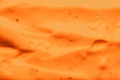 Texture of body cream as background, closeup. Toned in orange