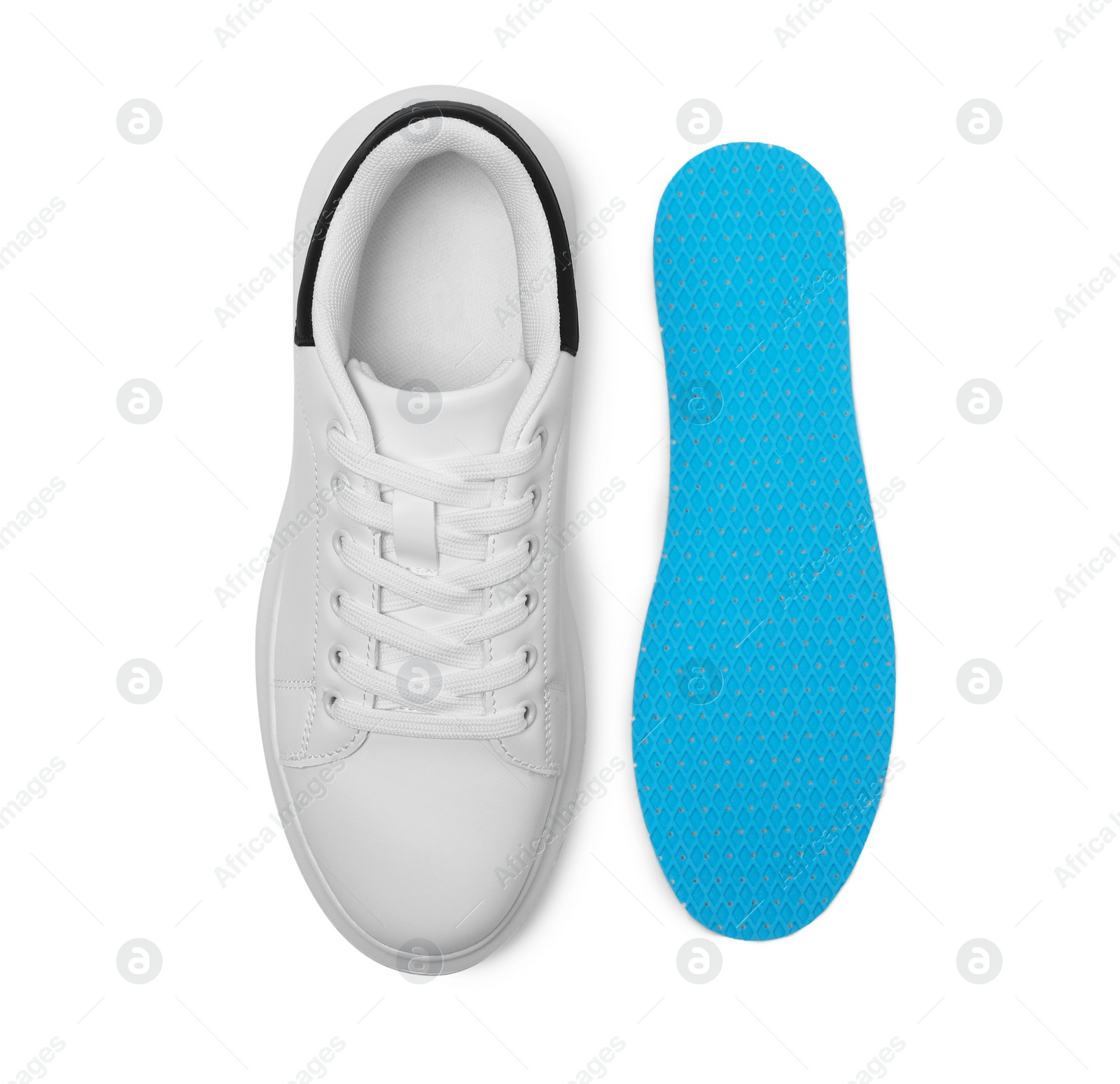 Photo of Orthopedic insole near shoe on white background, top view