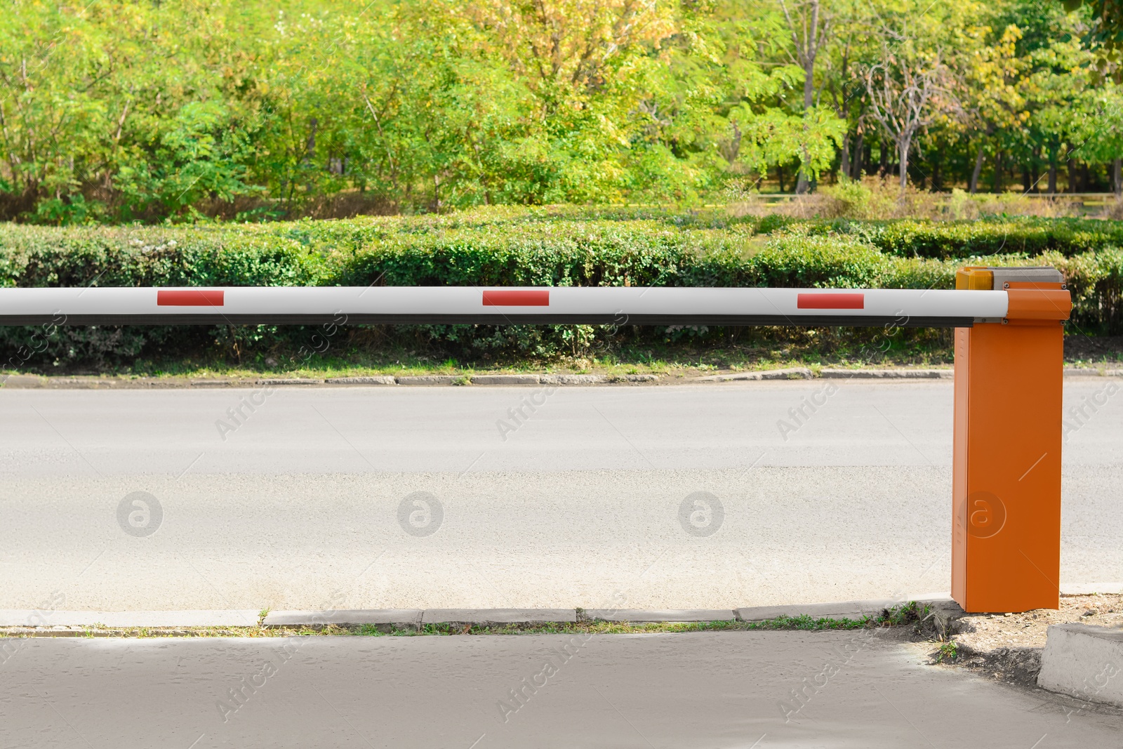 Photo of Closed boom barrier near road on sunny day