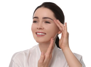 Photo of Young woman massaging her face on white background