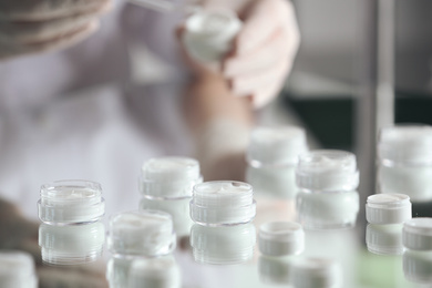 Photo of Jars with different cosmetic products in laboratory