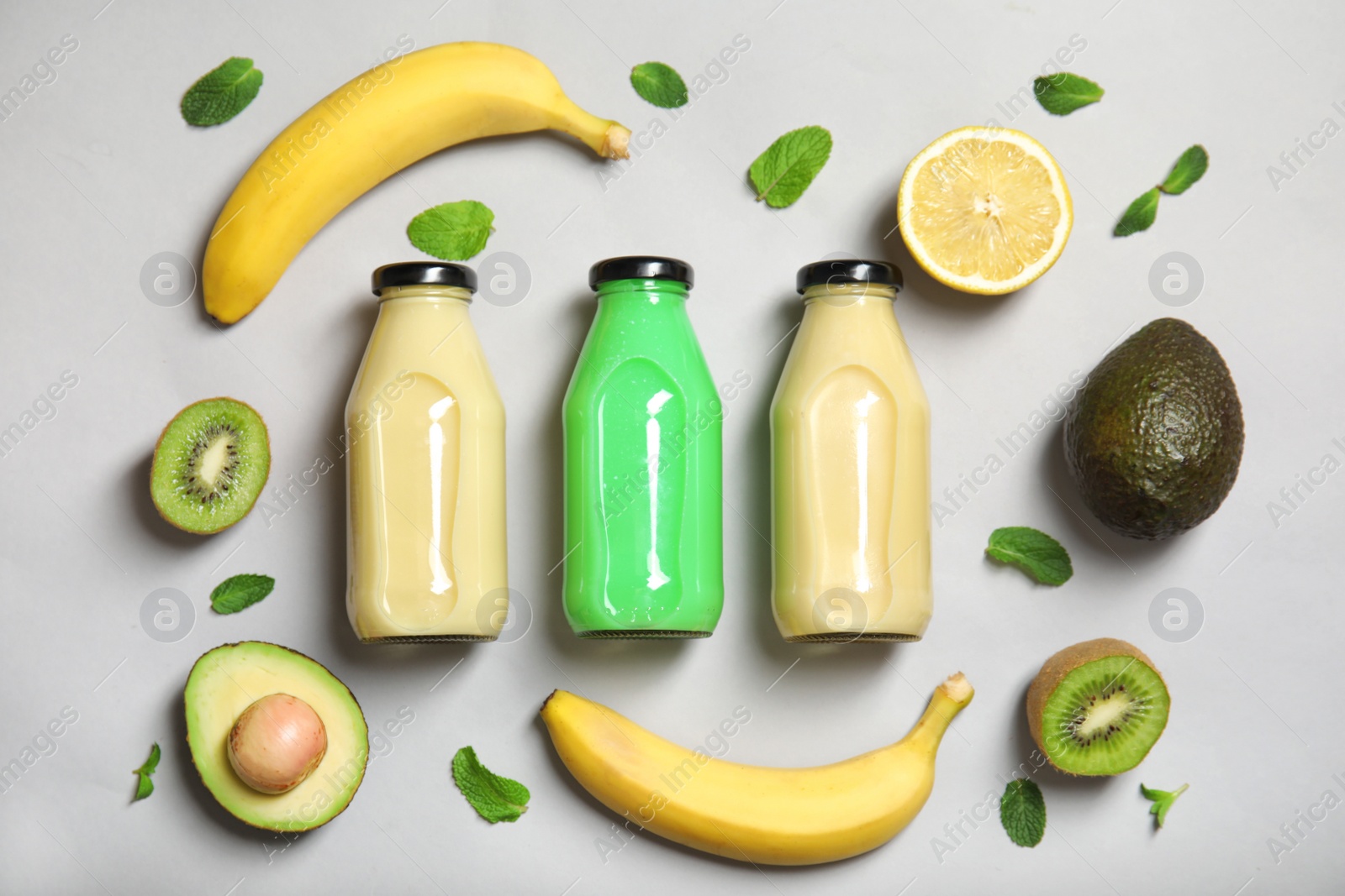 Photo of Flat lay composition with different smoothies in bottles and ingredients on color background