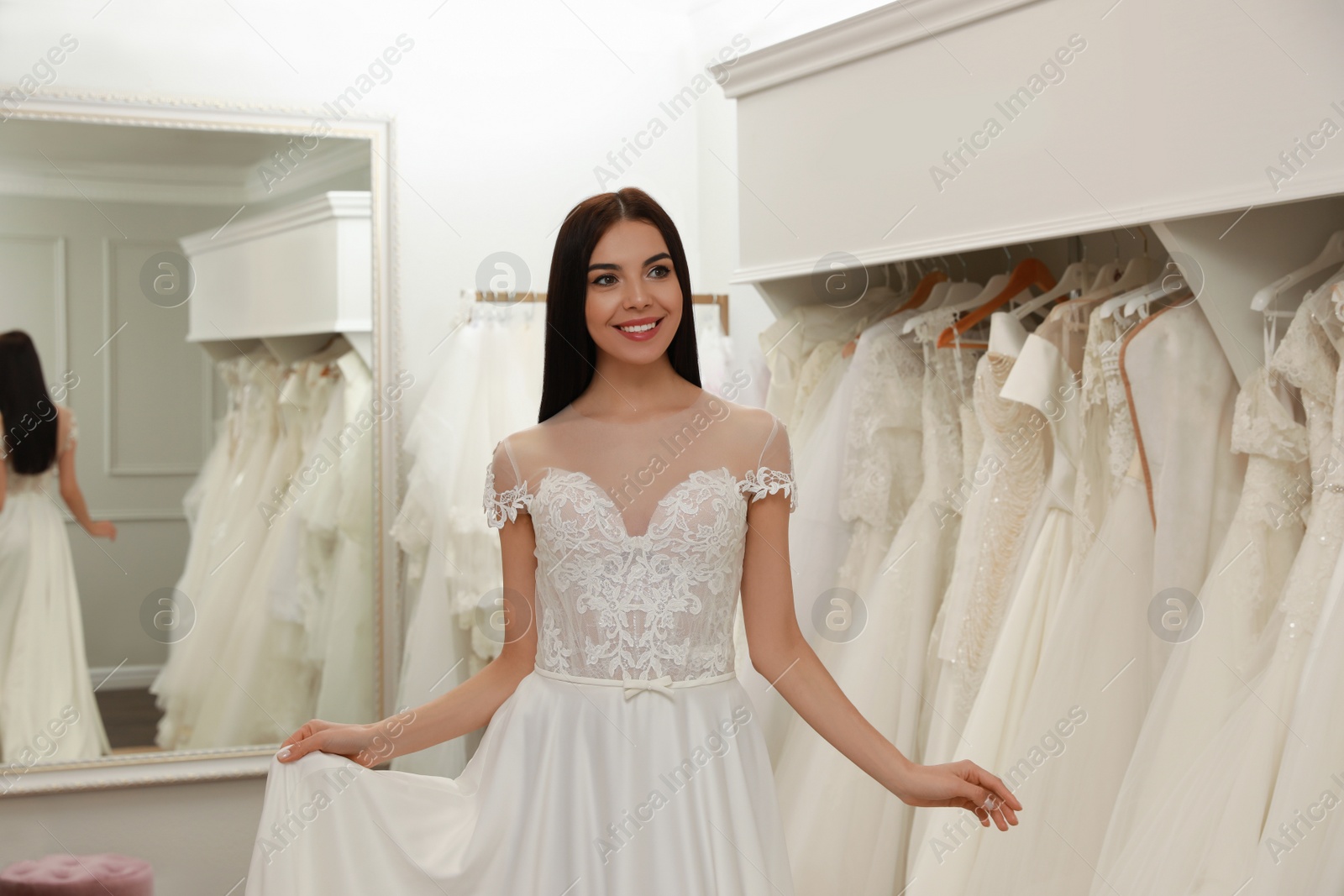 Photo of Woman trying on beautiful wedding dress in boutique