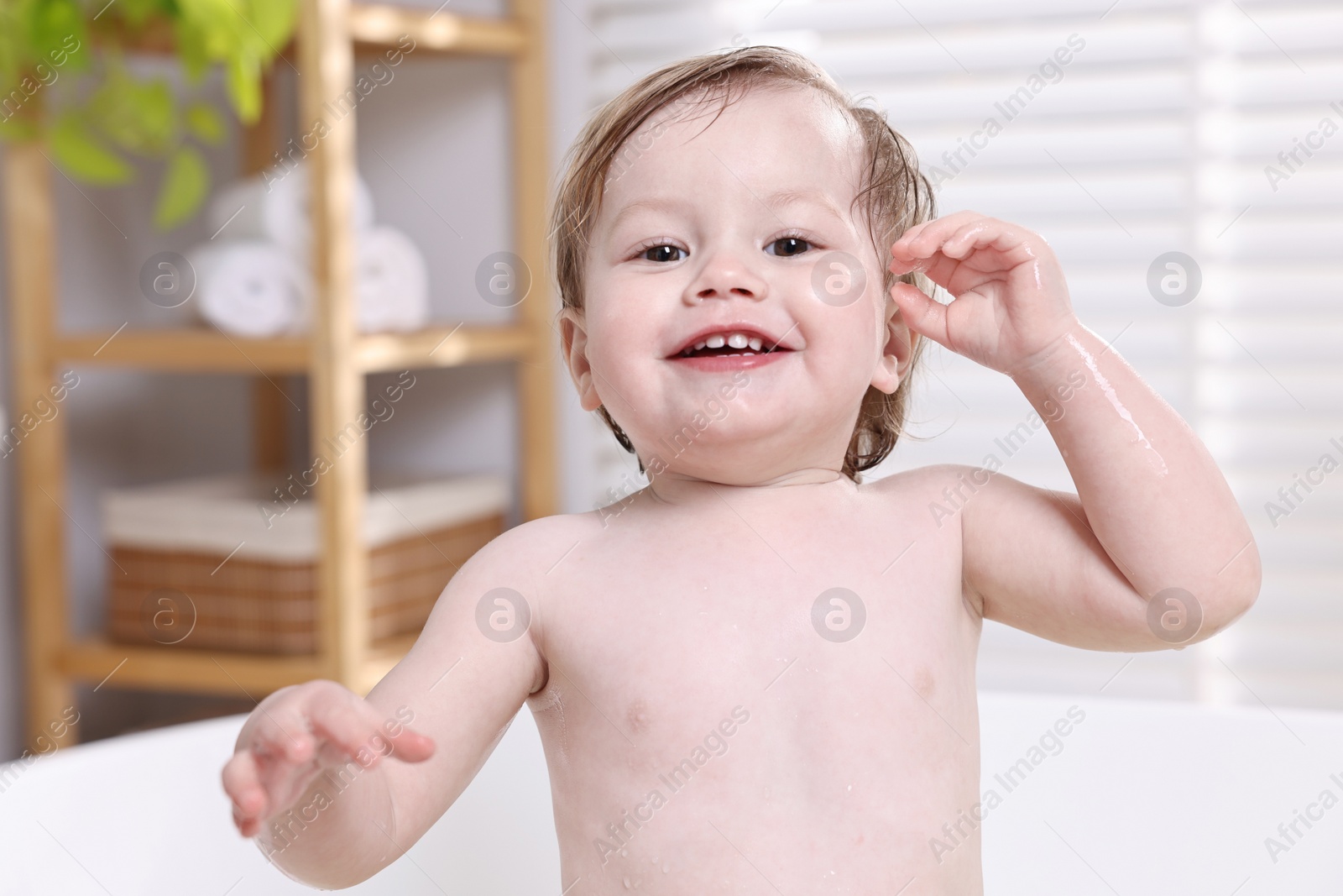 Photo of Cute little child bathing in tub at home