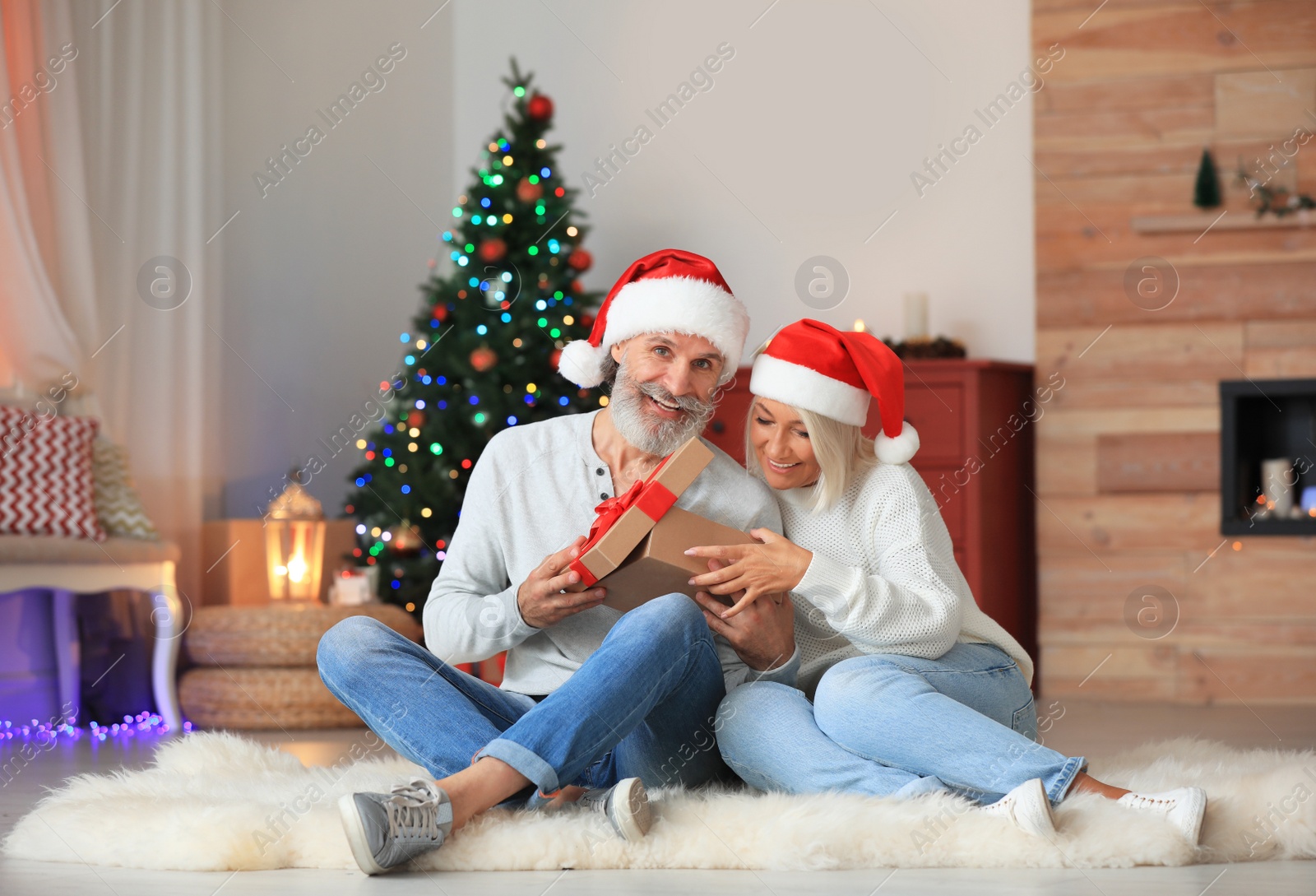 Photo of Happy couple opening Christmas gift at home