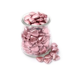 Glass jar and delicious heart shaped candies on white background