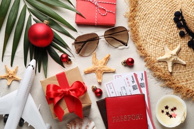 Photo of Flat lay composition with airline tickets, passport and festive decor on sand, flat lay. Christmas vacation