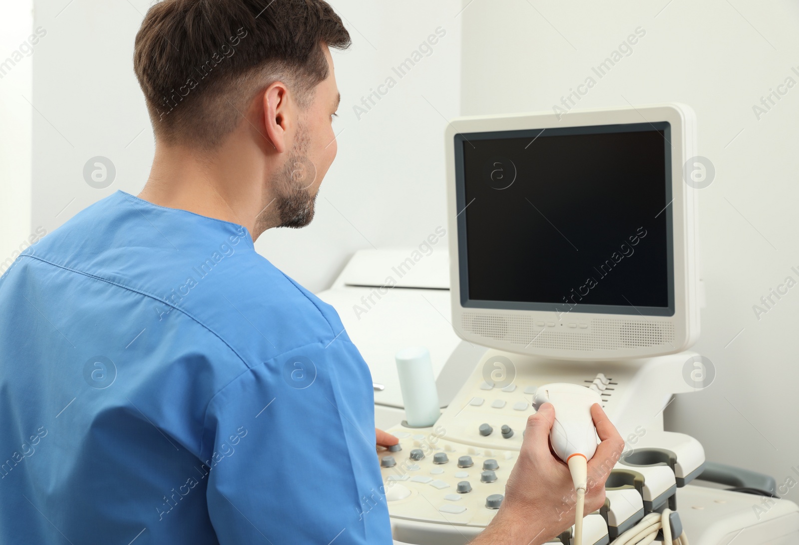 Photo of Sonographer operating modern ultrasound machine in clinic