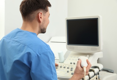 Sonographer operating modern ultrasound machine in clinic