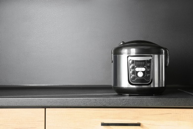 Photo of Modern multi cooker in kitchen, space for text. Domestic appliance