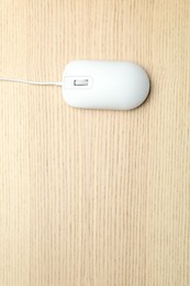 Photo of Wired computer mouse on wooden background, top view. Space for text