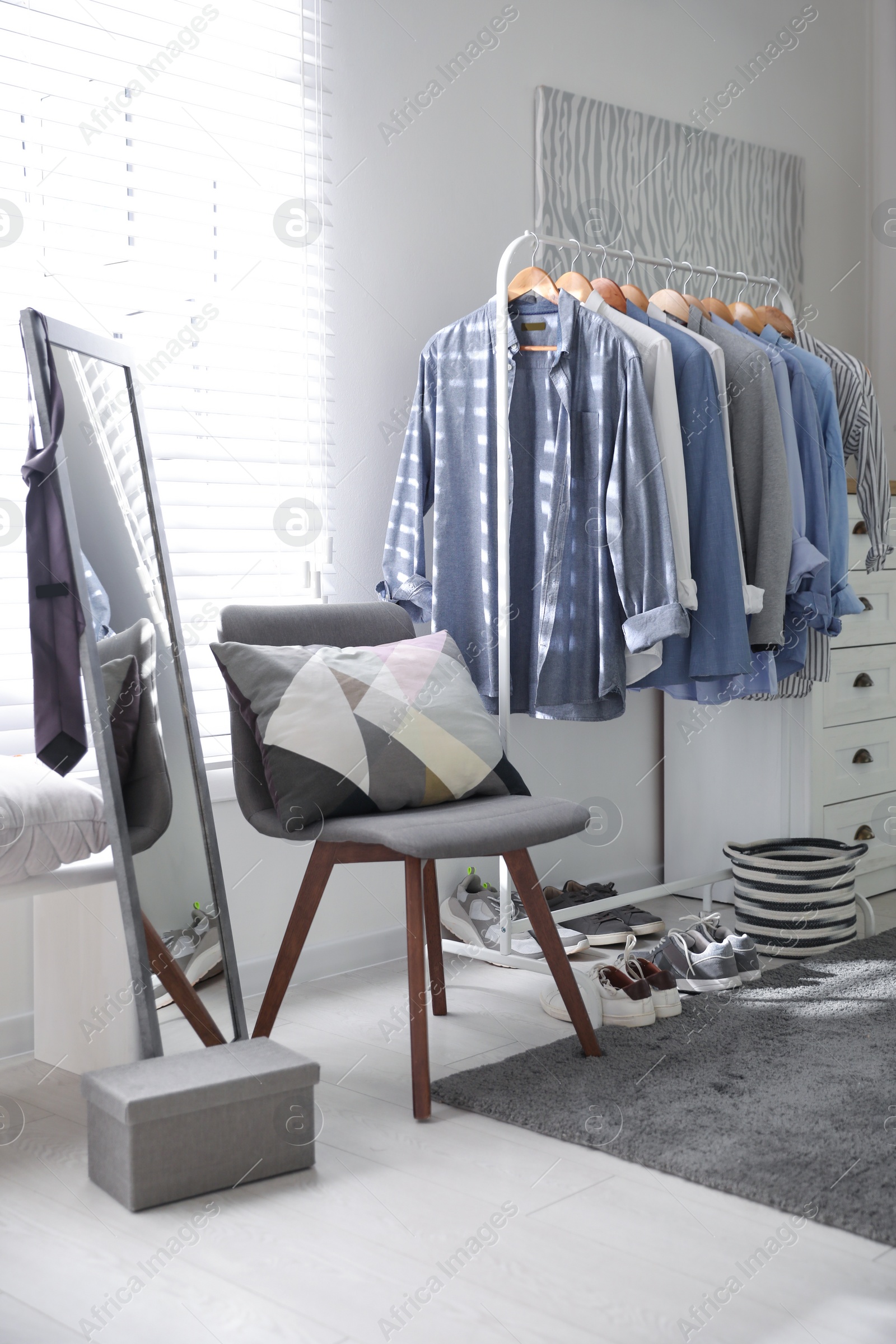 Photo of Dressing room interior with clothing rack and mirror