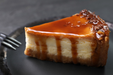 Photo of Piece of delicious cake with caramel on plate, closeup