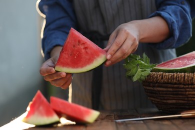 Photo of Woman holding slice of delicious ripe watermelon outdoors, closeup