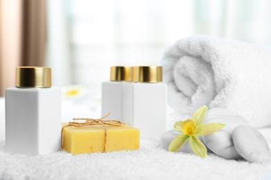 Photo of Composition with cosmetic products on white towel indoors. Spa therapy