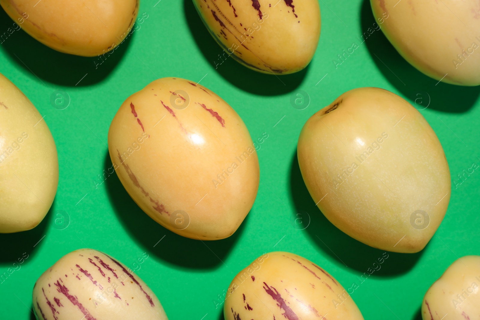 Photo of Fresh ripe pepino melons on green background, flat lay