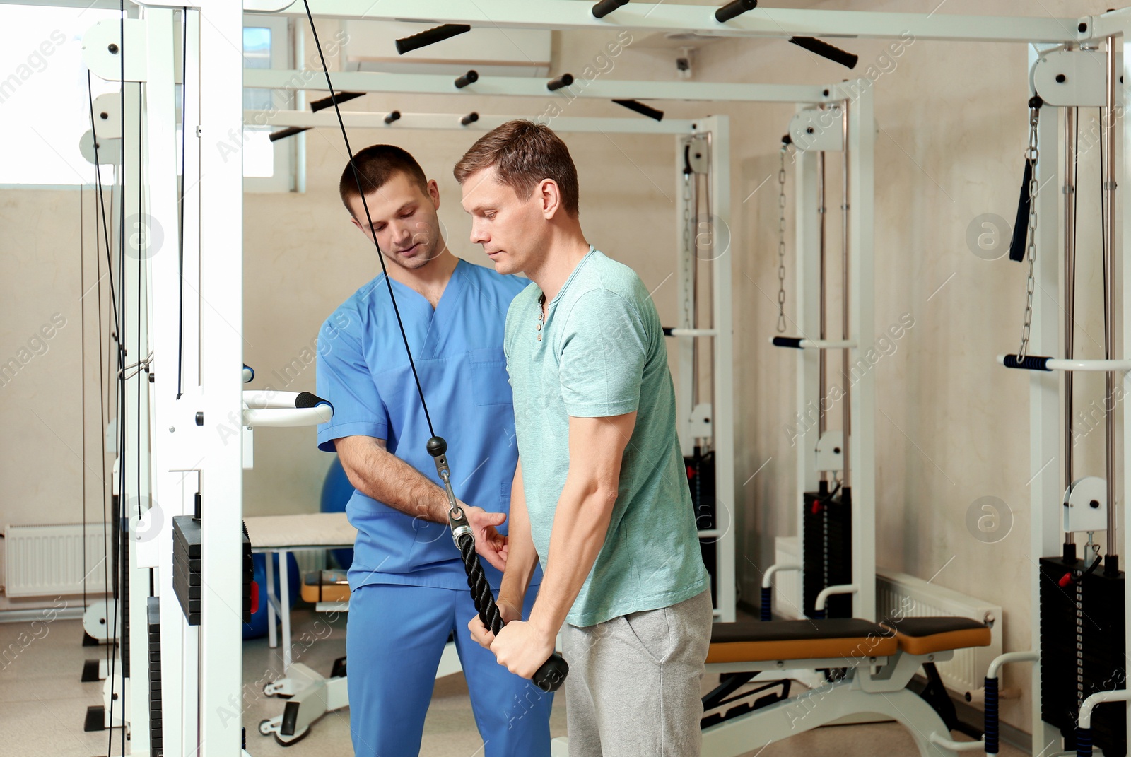 Photo of Patient exercising under physiotherapist supervision in rehabilitation center