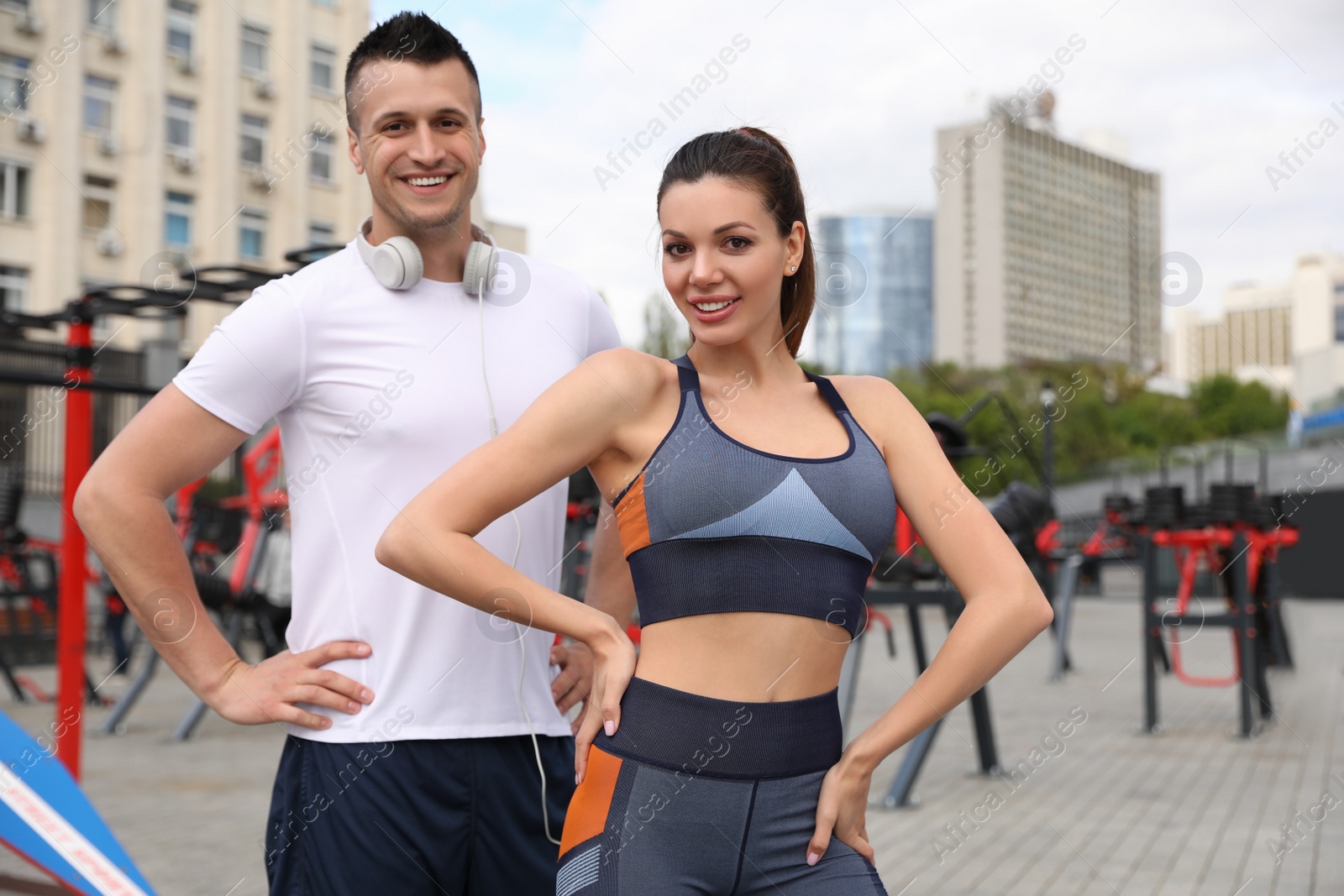 Photo of Woman and man in fitness clothes near outdoor gym