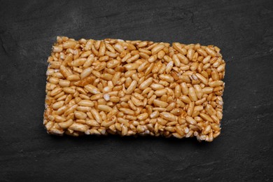 Photo of Puffed rice bar (kozinaki) on black table, top view