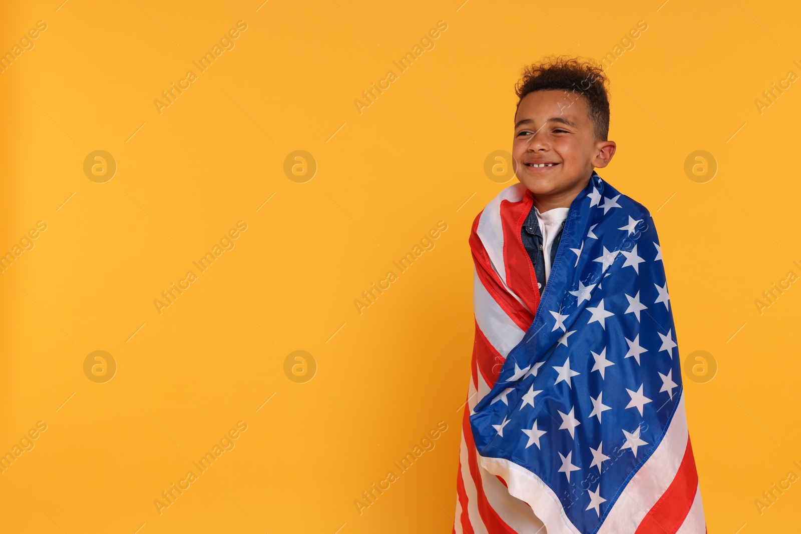 Photo of 4th of July - Independence Day of USA. Happy boy with American flag on yellow background, space for text