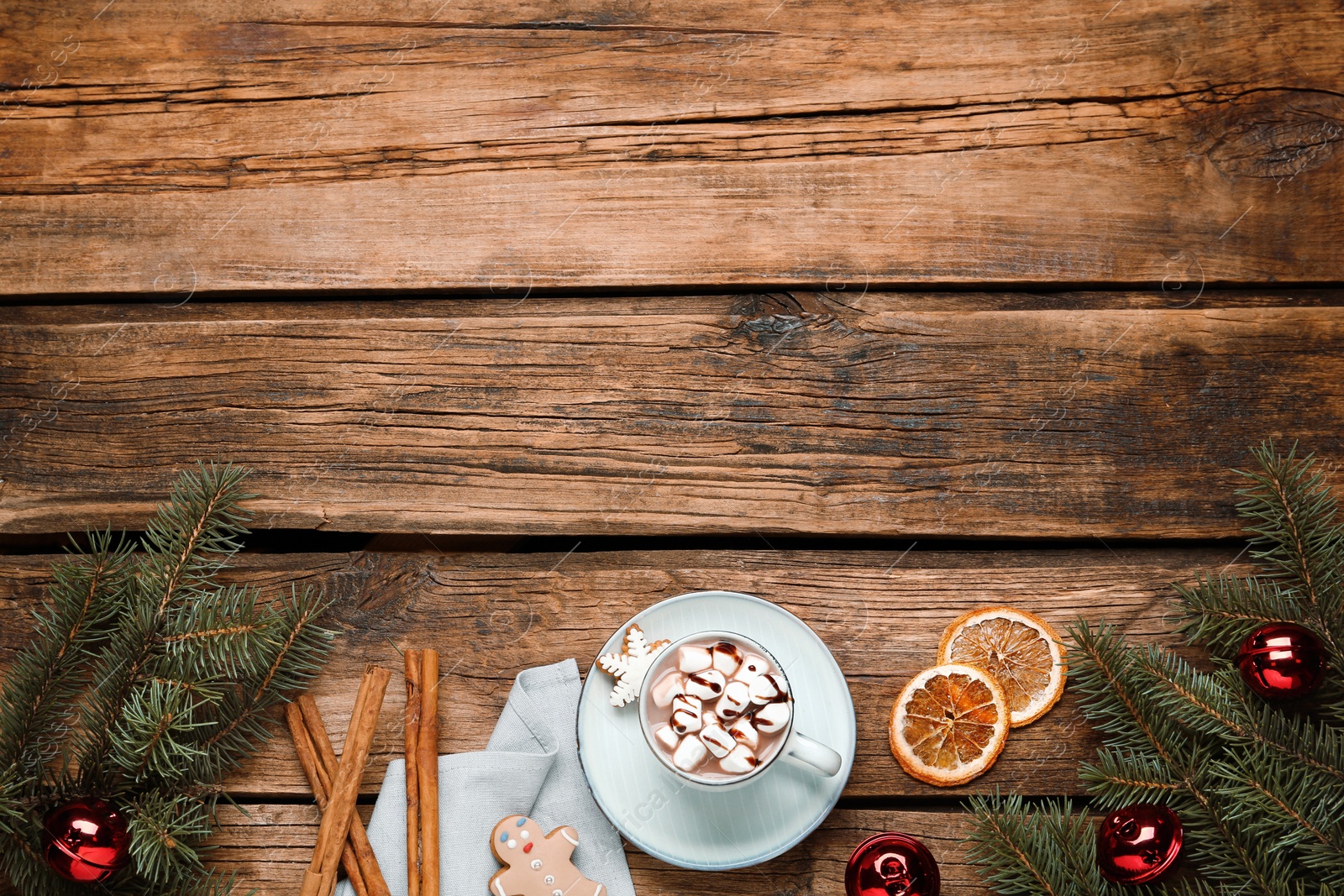 Photo of Flat lay composition of delicious hot chocolate with marshmallows and Christmas decor on wooden table, space for text