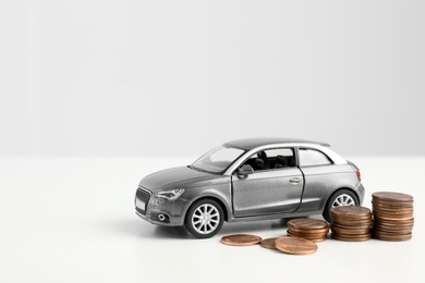 Toy car and money on white background, space for text. Vehicle insurance