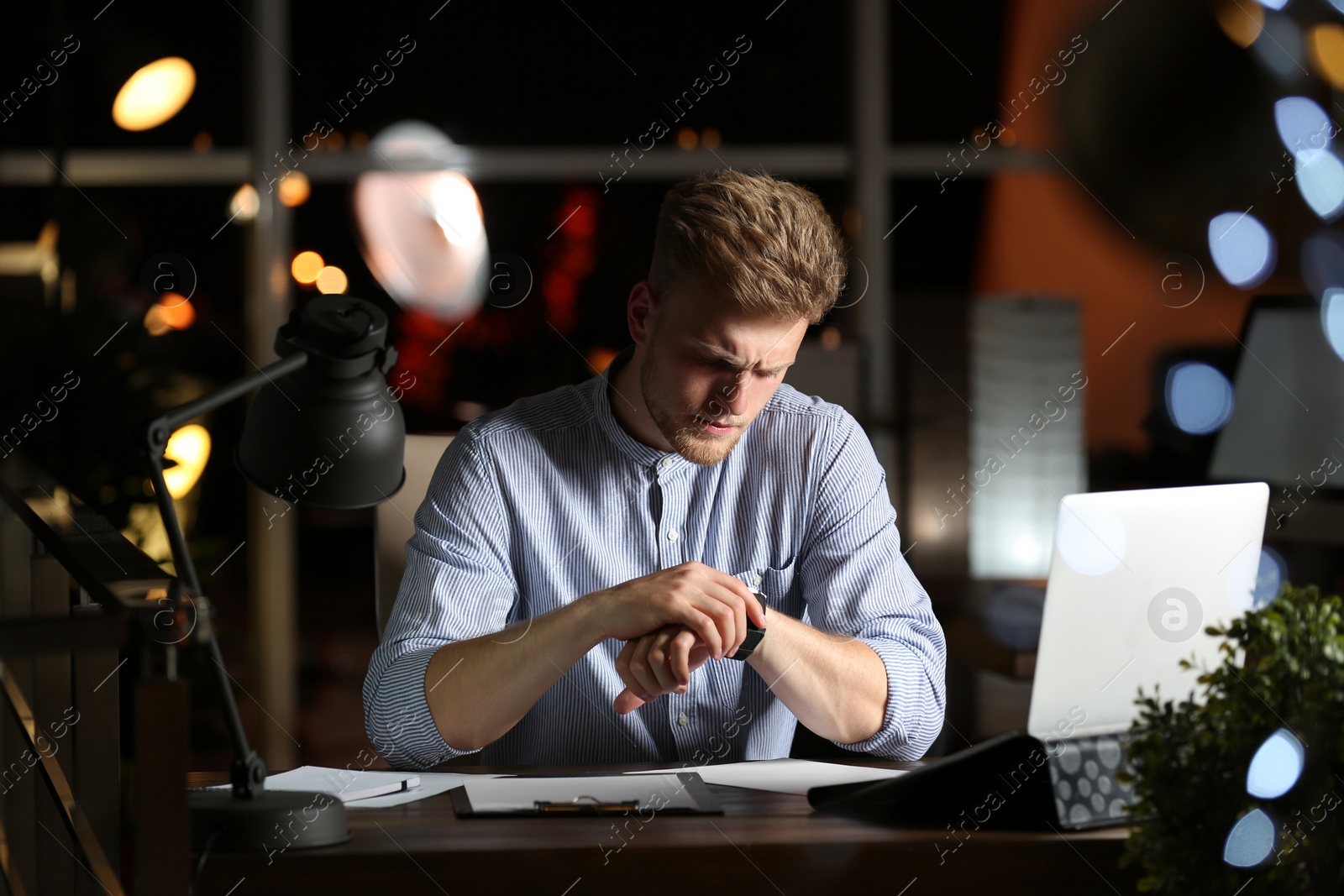 Photo of Young man working in office at night