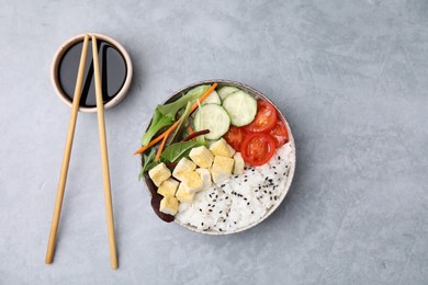 Photo of Delicious poke bowl with vegetables, tofu and mesclun served on light grey table, flat lay
