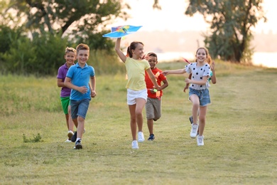 Photo of Cute little children playing with kite outdoors