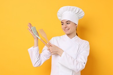 Photo of Professional chef with kitchen utensils on yellow background