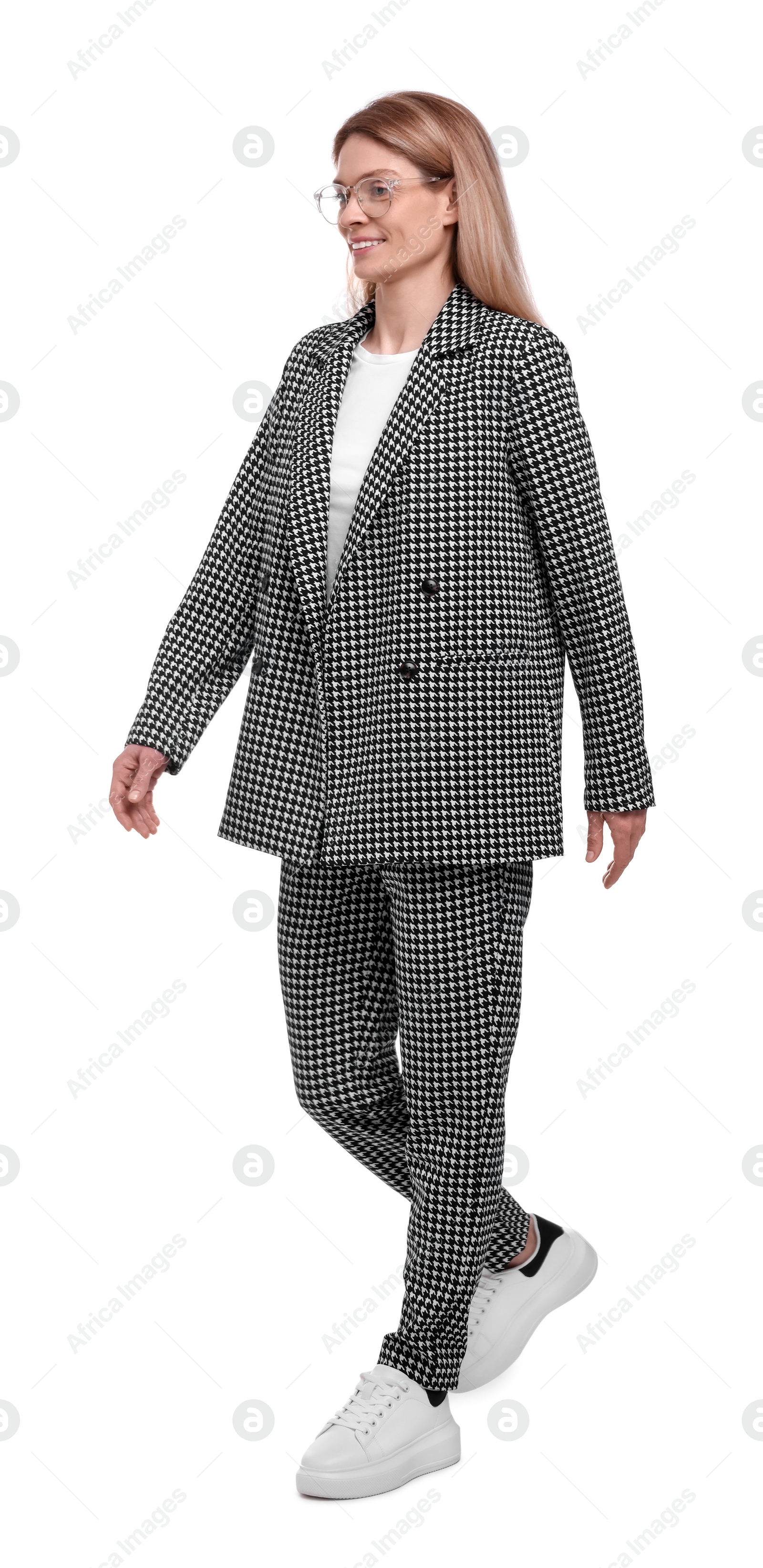 Photo of Beautiful happy businesswoman in suit walking on white background