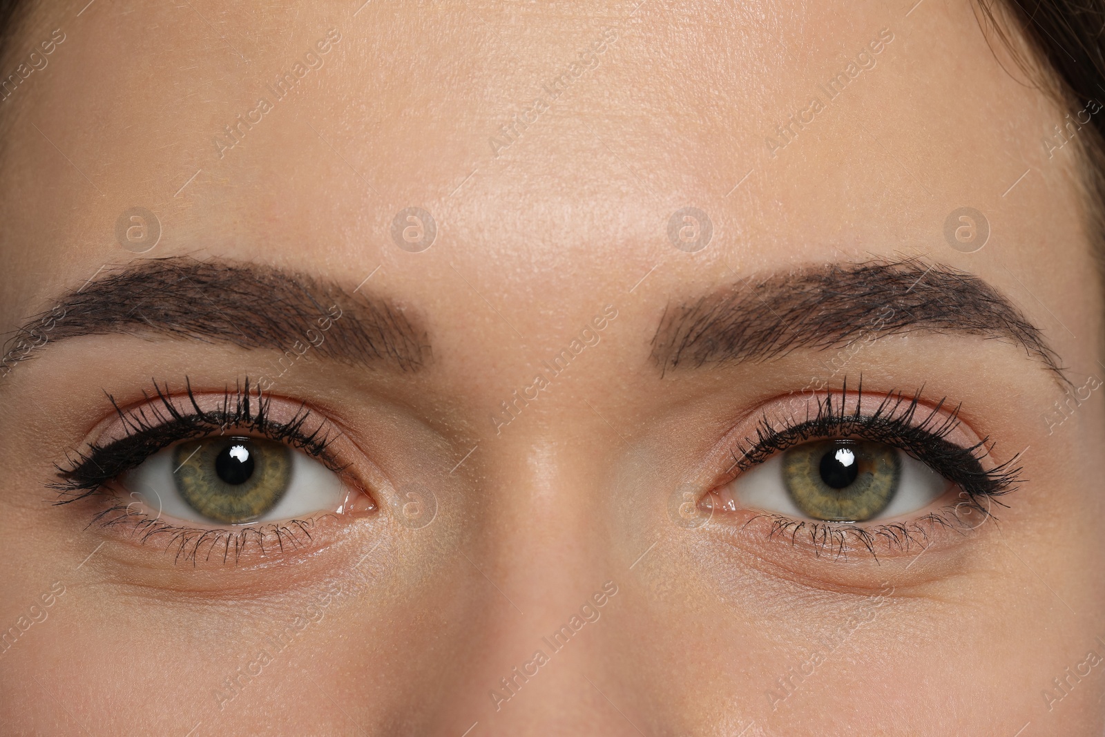 Photo of Young woman with permanent makeup of eyes and brows, closeup