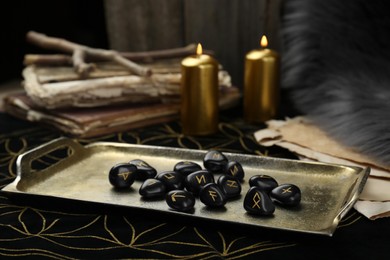 Tray with many black rune stones on divination mat, closeup
