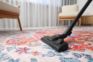 Photo of Dry cleaner's employee hoovering carpet with vacuum cleaner indoors, space for text