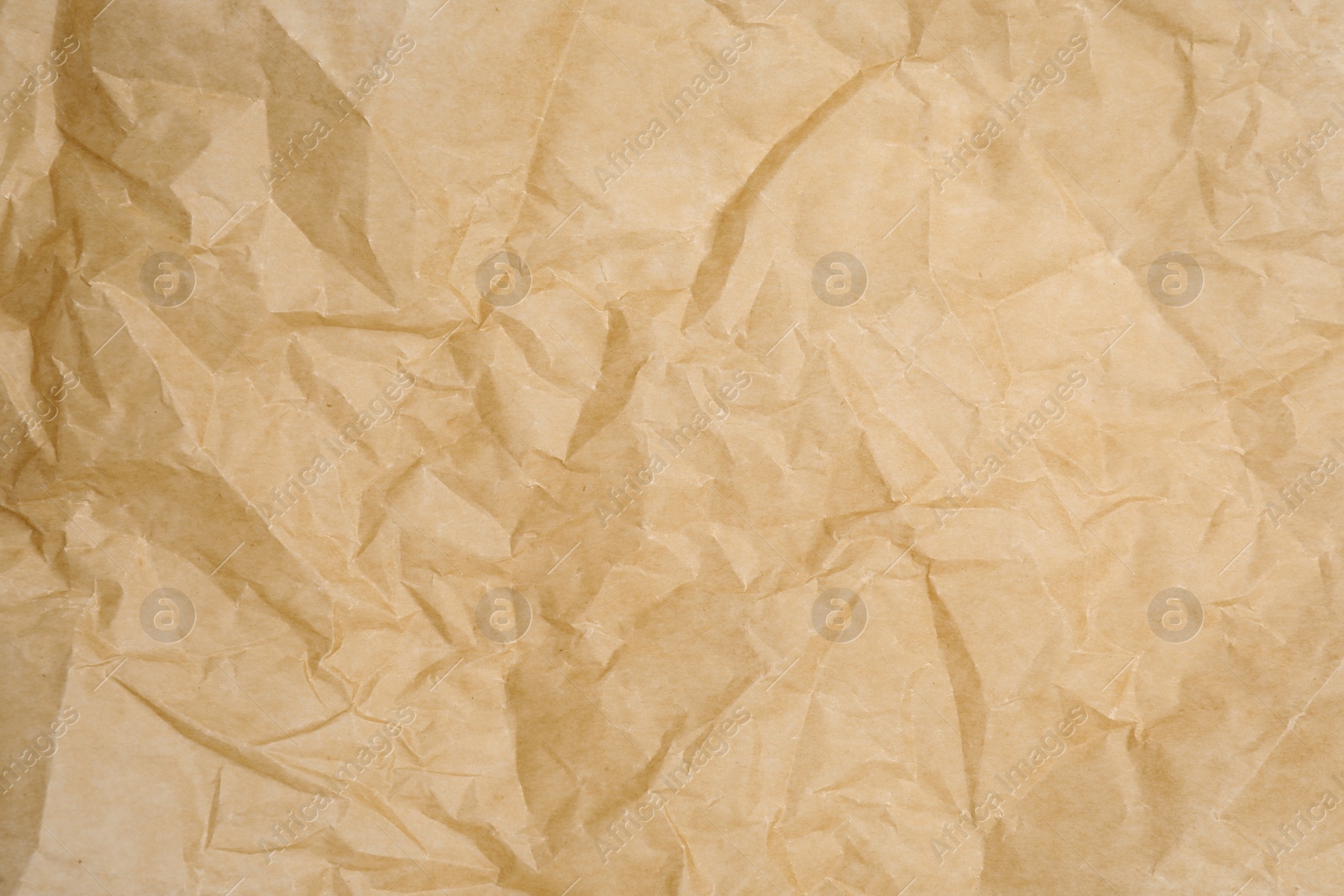 Photo of Texture of crumpled brown baking paper as background, closeup